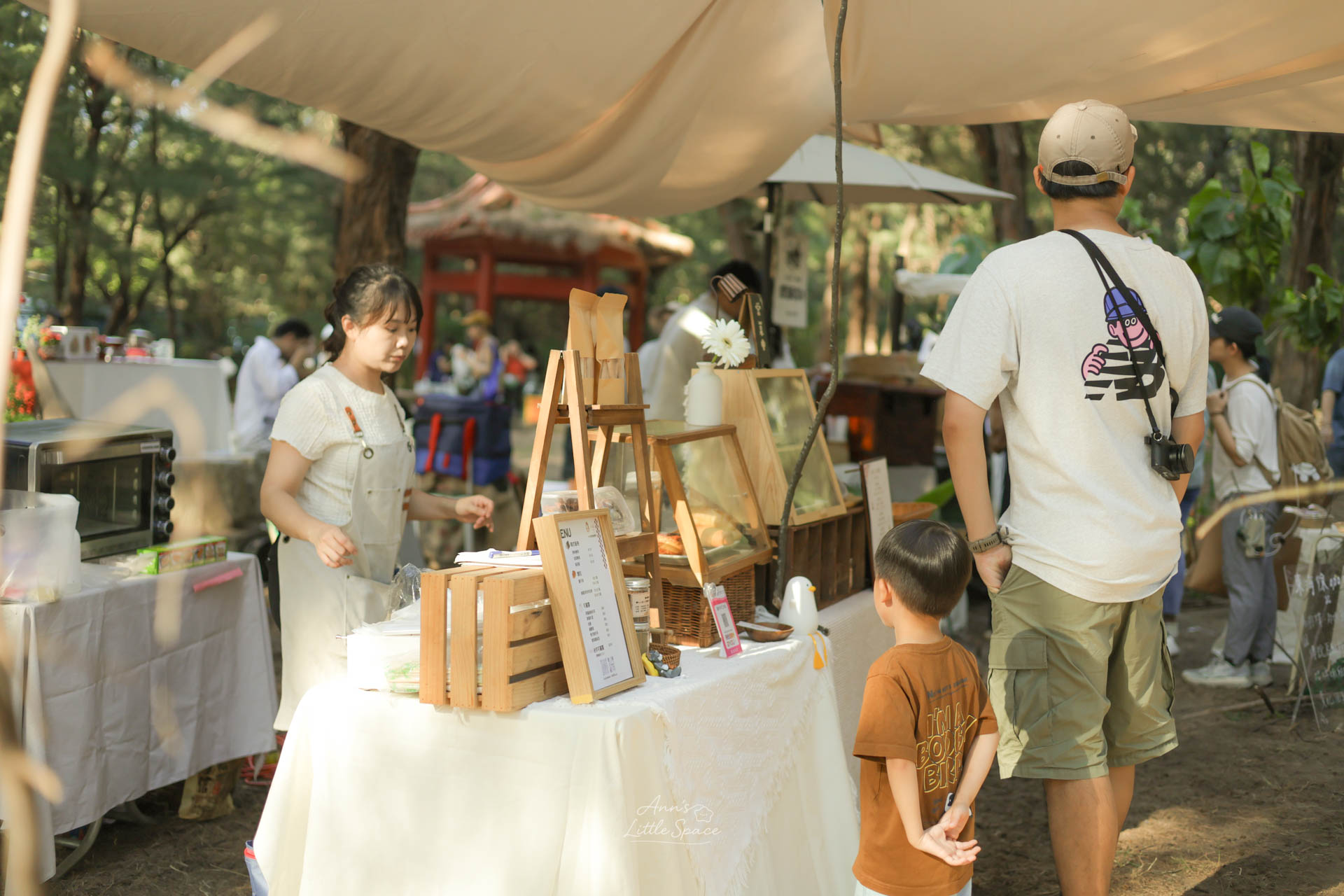 灰熊綠展森林系市集攤位，陽光灑落在木質風格甜點攤與逛市集的人群之間｜by Ann's Little Space
